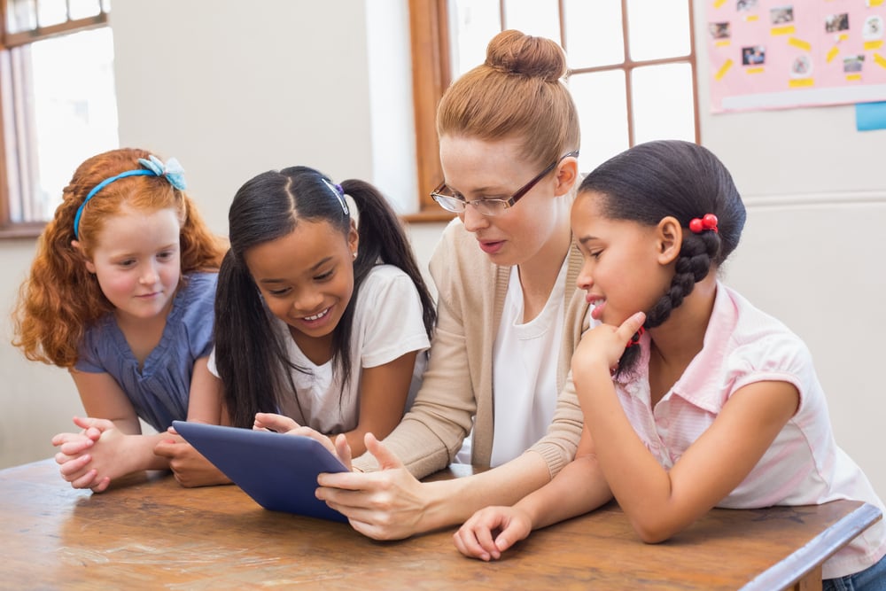 Teacher and pupils looking at tablet computer at the elementary school-1