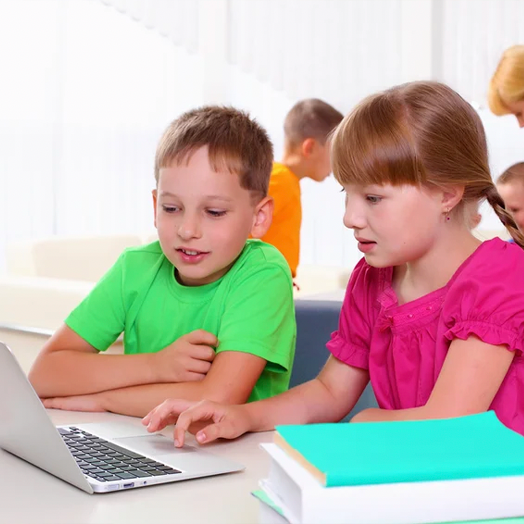boy and girl using laptop at school